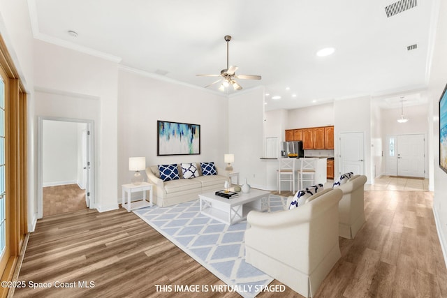 3980 Funston Cir, Melbourne, FL 32940 - living area featuring light wood-type flooring, visible vents, ceiling fan, crown molding, and baseboards