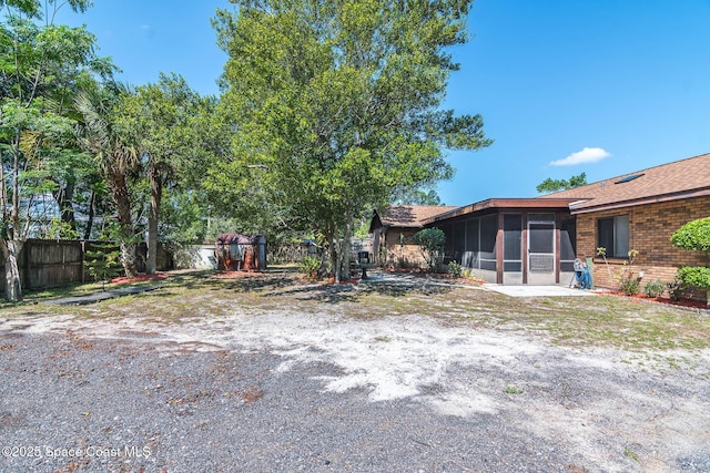 view of yard featuring a sunroom and fence