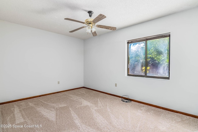 carpeted empty room featuring a textured ceiling, ceiling fan, and baseboards