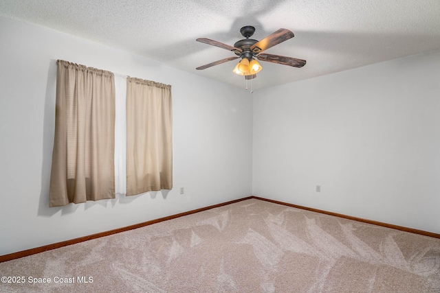 empty room with ceiling fan, baseboards, a textured ceiling, and carpet floors