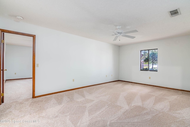 spare room with visible vents, ceiling fan, carpet, and baseboards