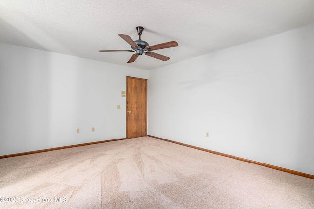 carpeted empty room with baseboards, a textured ceiling, and ceiling fan