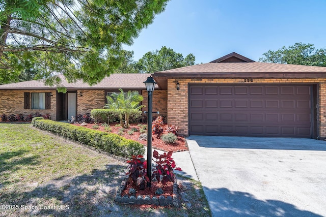 single story home featuring brick siding, an attached garage, driveway, and a front lawn