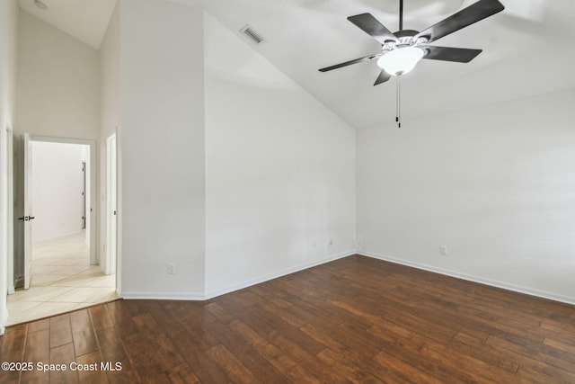 empty room featuring high vaulted ceiling, hardwood / wood-style floors, ceiling fan, baseboards, and visible vents