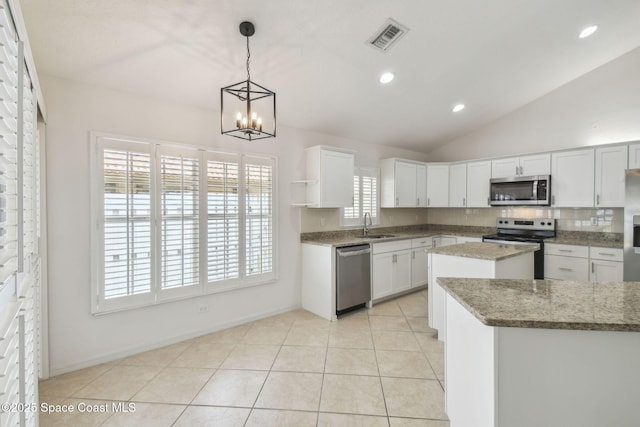 kitchen with a notable chandelier, appliances with stainless steel finishes, a sink, and white cabinetry