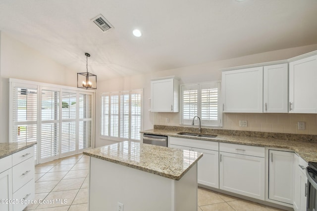 kitchen with stainless steel dishwasher, a sink, light tile patterned floors, visible vents, and a kitchen island