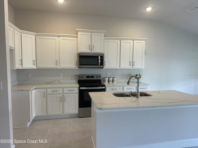 kitchen with visible vents, a sink, white cabinetry, stainless steel appliances, and light stone countertops