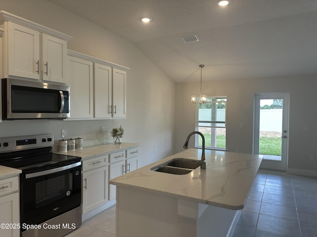 kitchen featuring visible vents, a sink, lofted ceiling, appliances with stainless steel finishes, and a kitchen island with sink