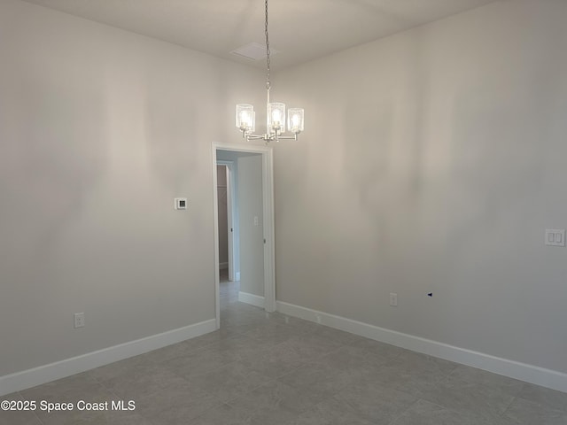 spare room with visible vents, baseboards, and a chandelier