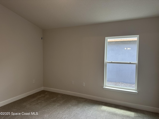 carpeted empty room with baseboards