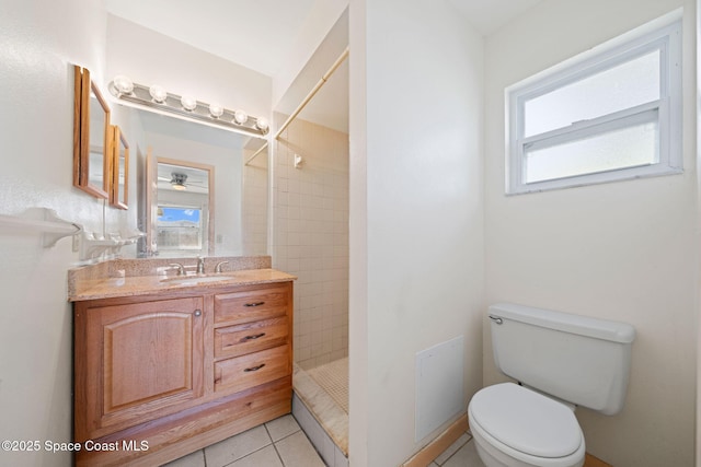 bathroom featuring tile patterned flooring, ceiling fan, toilet, a tile shower, and vanity