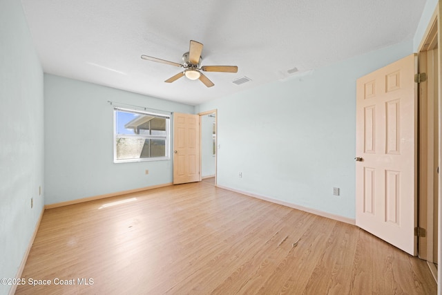 spare room with light wood-style flooring, baseboards, visible vents, and ceiling fan