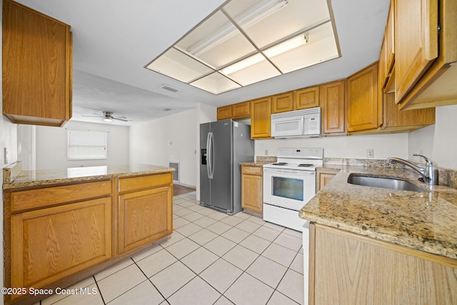 kitchen featuring ceiling fan, light stone countertops, light tile patterned floors, white appliances, and a sink