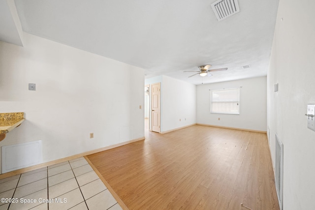 unfurnished living room with visible vents, baseboards, light wood-style floors, and ceiling fan