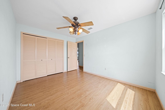 unfurnished bedroom featuring a closet, baseboards, and wood finished floors