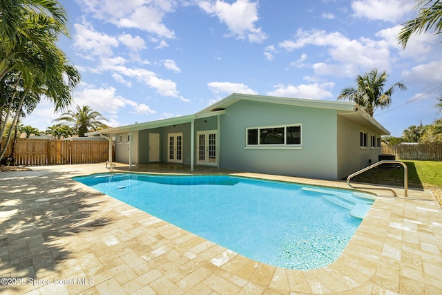 view of swimming pool featuring a patio area, a fenced in pool, french doors, and a fenced backyard