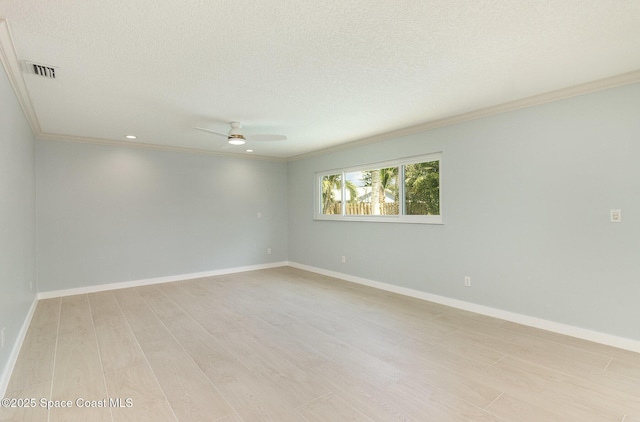 empty room with visible vents, baseboards, crown molding, and light wood-style floors