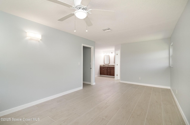 unfurnished room featuring visible vents, light wood-style floors, baseboards, and ceiling fan