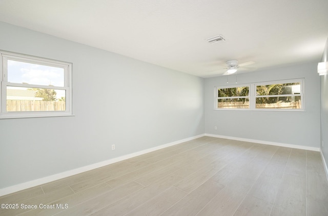 unfurnished room with baseboards, light wood-style floors, and ceiling fan