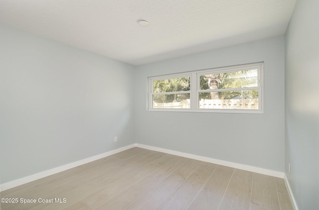 empty room with light wood-style flooring and baseboards