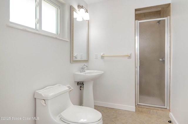 bathroom featuring tile patterned flooring, a shower stall, toilet, and baseboards