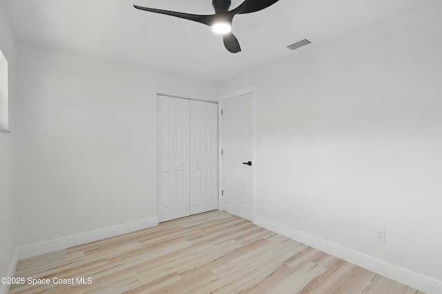 spare room featuring visible vents, baseboards, ceiling fan, and wood finished floors