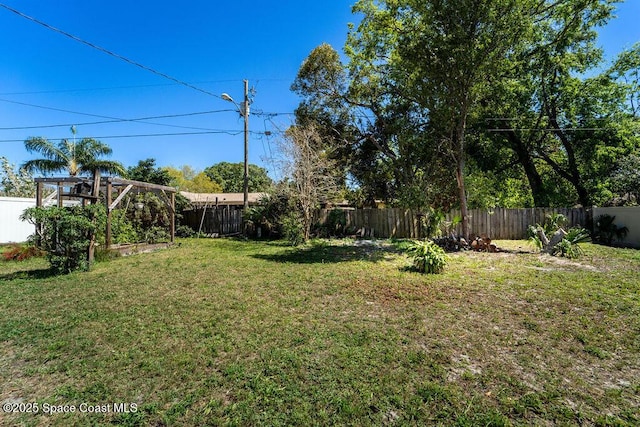 view of yard with a garden and a fenced backyard