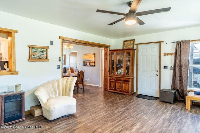 sitting room featuring wood finished floors, baseboards, and ceiling fan