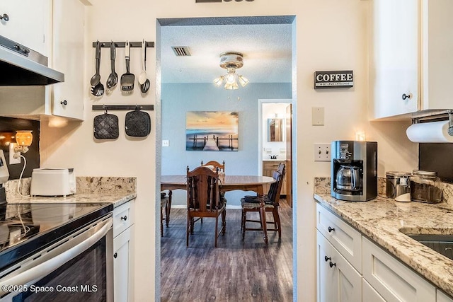 kitchen with visible vents, dark wood finished floors, stainless steel range with electric cooktop, white cabinets, and under cabinet range hood