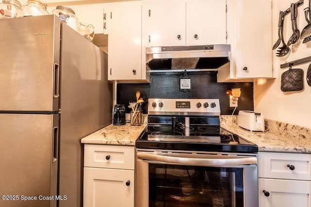 kitchen with stainless steel range with electric stovetop, under cabinet range hood, backsplash, white cabinetry, and freestanding refrigerator