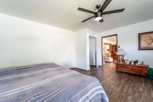 bedroom with a ceiling fan, wood finished floors, and baseboards