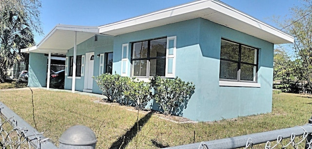 1630 S St, Titusville, FL 32780 - view of side of home featuring a lawn and stucco siding
