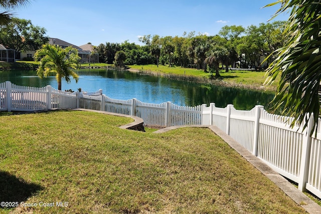 view of yard with a fenced backyard and a water view