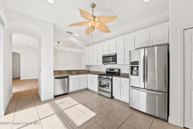 8652 Villanova Dr Unit 1001, Cape Canaveral, FL 32920 - kitchen featuring appliances with stainless steel finishes, arched walkways, light tile patterned floors, recessed lighting, and white cabinetry