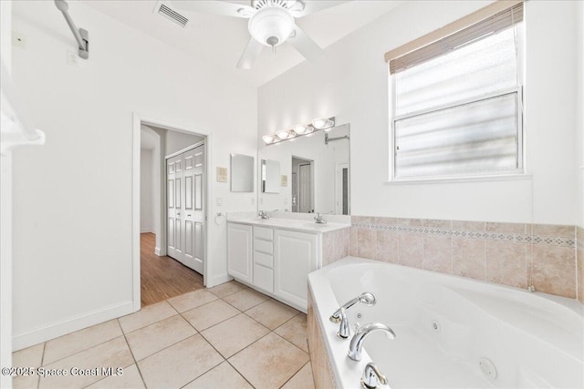 8652 Villanova Dr Unit 1001, Cape Canaveral, FL 32920 - full bathroom featuring a whirlpool tub, vanity, tile patterned floors, a ceiling fan, and baseboards