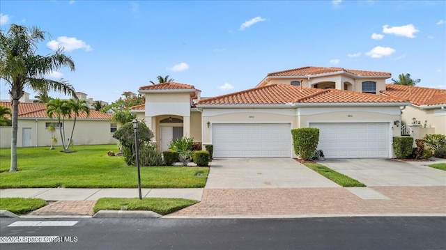 8652 Villanova Dr Unit 1001, Cape Canaveral, FL 32920 - mediterranean / spanish-style house with driveway, a garage, a front lawn, stucco siding, and a tiled roof