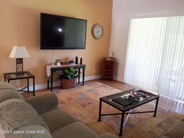 living area featuring baseboards and wood finished floors