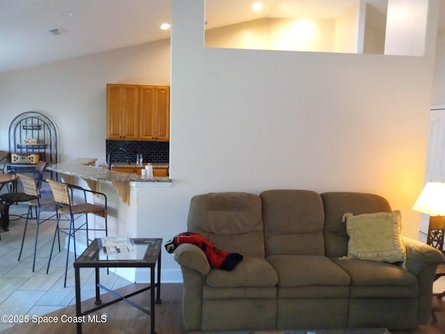 living room with lofted ceiling, recessed lighting, and visible vents