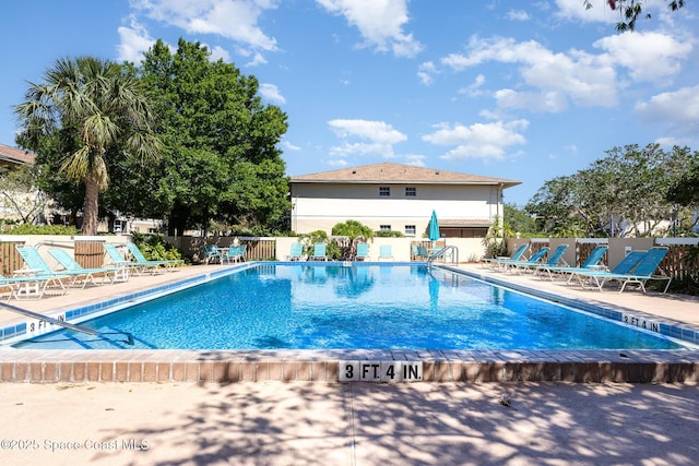 community pool featuring a patio and fence