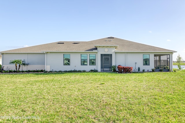 back of house featuring a yard, a sunroom, and stucco siding