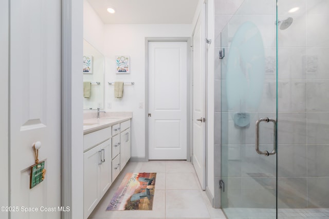 bathroom featuring a sink, recessed lighting, a shower stall, tile patterned flooring, and double vanity