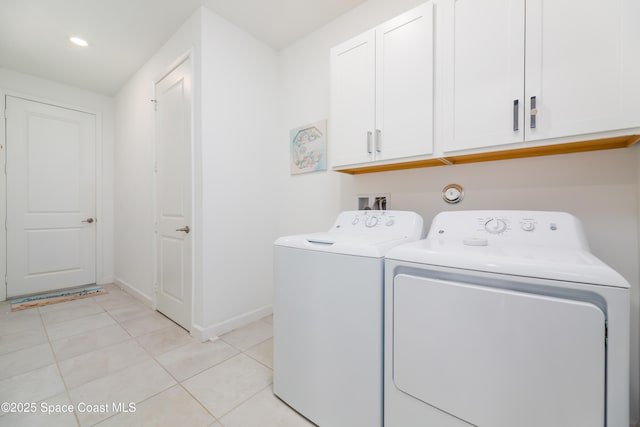 clothes washing area with light tile patterned floors, cabinet space, baseboards, and washer and clothes dryer