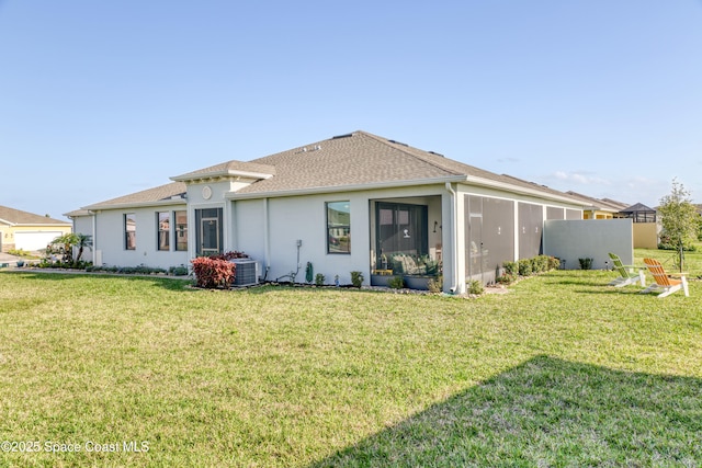rear view of house featuring stucco siding, central air condition unit, a lawn, and a sunroom