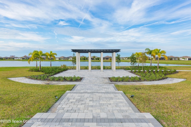 surrounding community featuring a pergola, a yard, and a water view