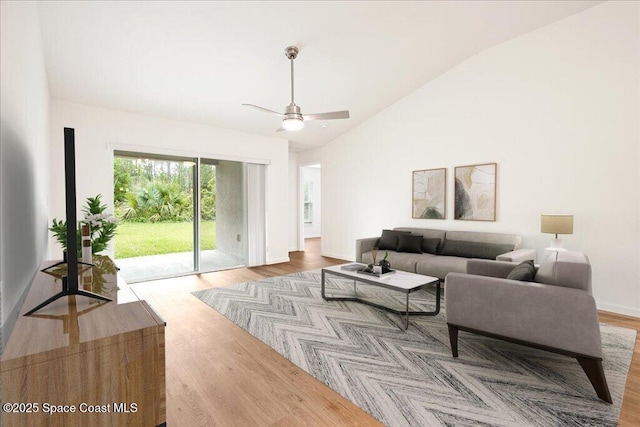 living area featuring baseboards, high vaulted ceiling, ceiling fan, and wood finished floors