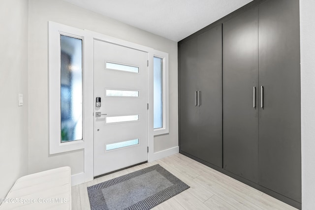 entryway with baseboards and light wood-style floors