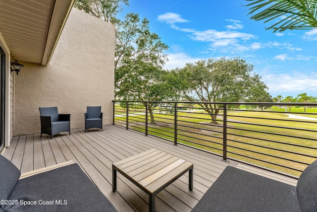 wooden terrace featuring a lawn