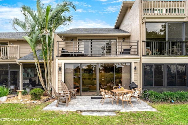 rear view of property with a patio area, stucco siding, and a balcony