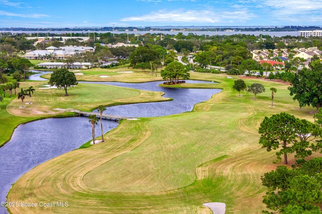 drone / aerial view with a water view and golf course view