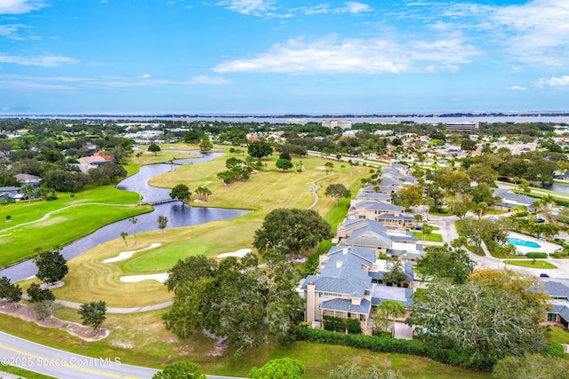 birds eye view of property with golf course view and a water view